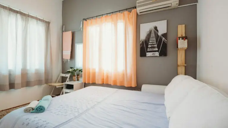 A bedroom with white curtains and soft lighting